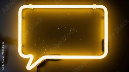 A bright yellow neon sign shaped like a speech bubble glows against a dark background, with subtle sparkling effects.