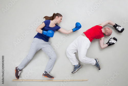 A woman punches a man during a playful boxing fight in a studio