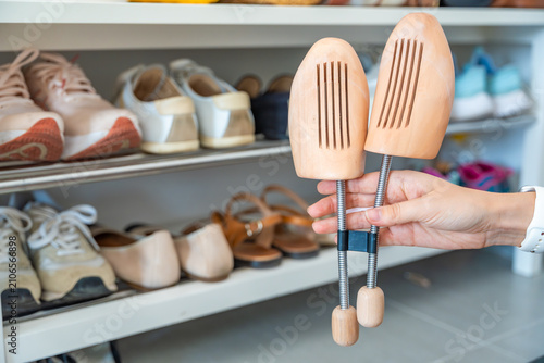 Obraz na płótnie Pair of wooden shoe trees displayed in front of a wardrobe filled with shoes