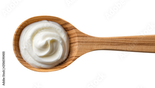 Fotografie Isolated wooden spoon with a delicious dollop of creamy white yogurt or fresh sour cream