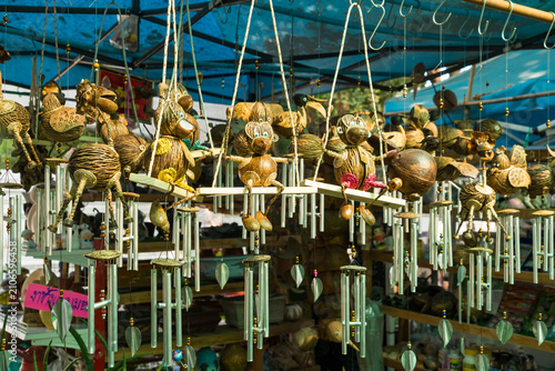 Handicraft Market Stall: A vibrant market stall displays a wide assortment of handcrafted wind chimes and decorative items made from natural materials.