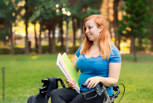 Obraz na płótnie College student studying outdoors with mobility aid preparing for university exa