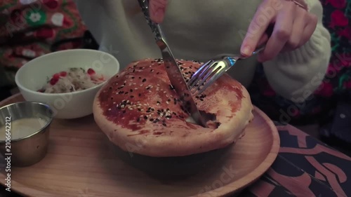 A man eats pulled beef with mashed potatoes baked in puff pastry
