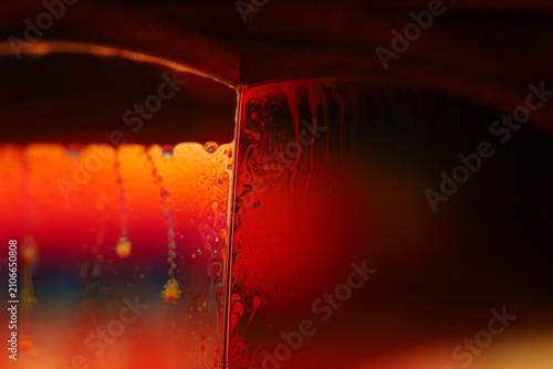 Fotografi Fiery red and orange fluid macro with vertical trickles and dripping partition