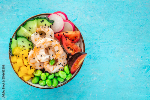 Poke bowl with shrimps, tomatoes, cucumber, mango, edamame, and radish