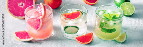 Refreshing summer cocktails with ice cubes on a light background