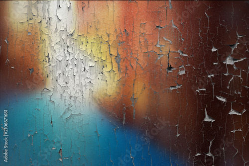 Vibrant abstract grunge texture with peeling multi-colored paint on an aged wall surface, revealing layers of decay and history