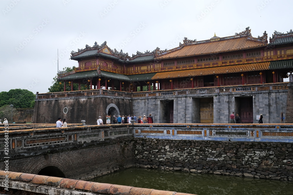 Fototapeta premium Tourists walking across the historic bridge at Hue Imperial City entrance in Vietnam
