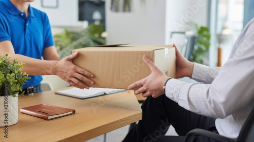 Two business professionals signing a contract at a wooden office table contract signing business agreement