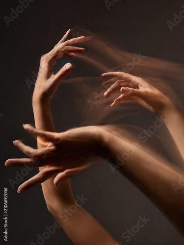 Two hands in motion, fingers spread apart, creating a dynamic and fluid image emphasizing movement and interaction.