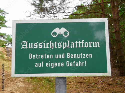 Schild mit der Aufschrift Aussichtsplattform - Betreten und Benutzen auf eigene Gefahr