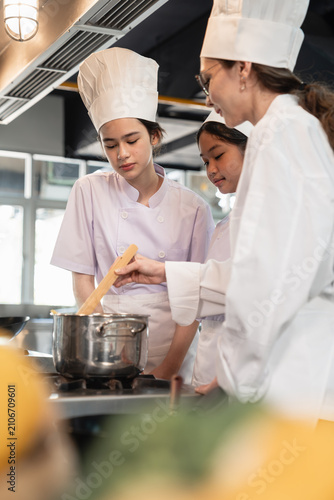 Obraz na plátne Chef Instructor Teaching Culinary Students How to Cook in a Pot During a Practic