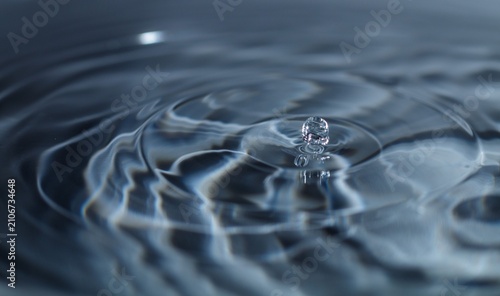 Фотография Macro Close Up of Water Droplet Impacting Liquid Surface Creating Ripples