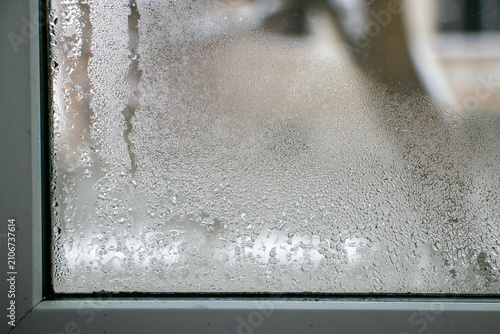 Foto Condensation of water droplets on a window indoors
