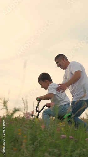 man father teaches boy son ride bike, schoolboy boy playing happily dad park, father running after bike child green meadow, happy family outdoors, children dream, adrenaline fast cycling, childhood