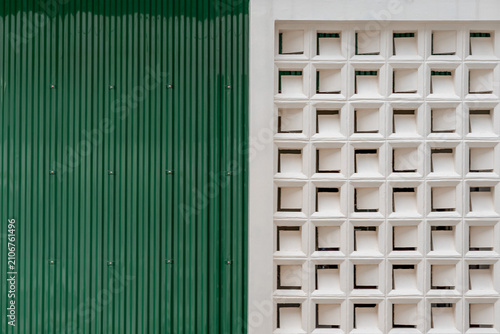 Green corrugated metal wall and white breeze block ventilation wall geometric texture background.