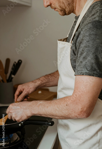 Man in a white apron cookin...