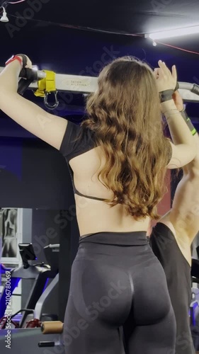 Girl performs pull up on horizontal bar during strength workout. Athlete raises body upward keeping arms and back engaged with control