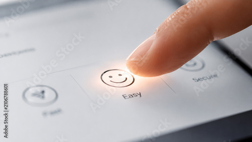 Close‑up of a finger pressing a touchscreen button with a smiling face icon labeled Easy alongside other options like Fast and Secure symbolizing positive interaction ease of use and technology prefer