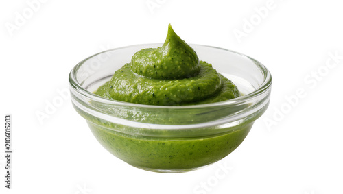 Obraz na płótnie Isolated green pesto sauce in a clear glass bowl, vibrant fresh herb dip or spre