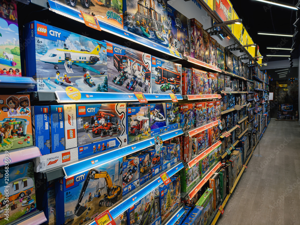 Fototapeta premium DNIPRO, UKRAINE - JULY 21, 2026: Perspective view of a long supermarket shelf packed with Lego City construction toy sets. Brightly lit aisle with numerous plastic building kits.