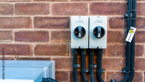 PV array DC isolator switches mounted on exterior brick wall