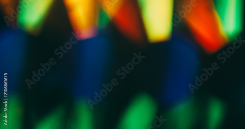 Color flare. Blur light rays. Defocused green blue red multicolor shine lens flare glare gleam glow on dark black abstract background.