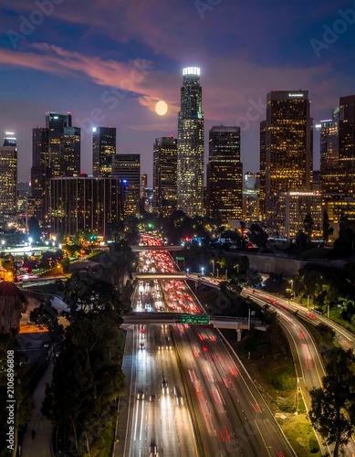 A nighttime cityscape with a full moon, busy highways, and skyscrapers
