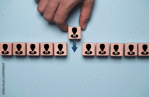 Bild auf Leinwand Employee turnover concept with a hand moving a wooden person block, representing staff replacement, workforce transition, recruitment, talent management, human resources and organizational change