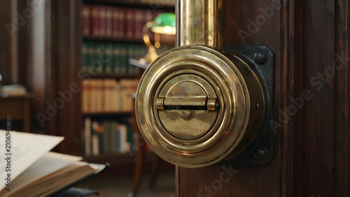 Vintage brass combination lock door handle with a bookshelf in background