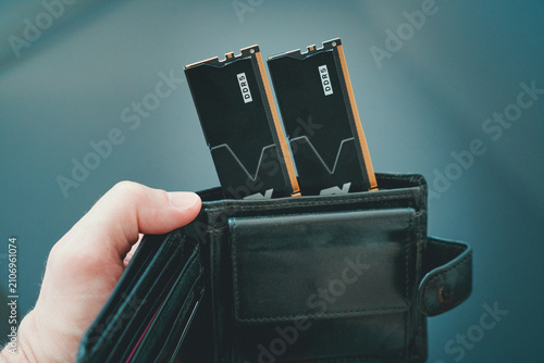 Black DDR5 RAM modules inside a black wallet held in hand, symbolizing high cost and value of memory for AI training.