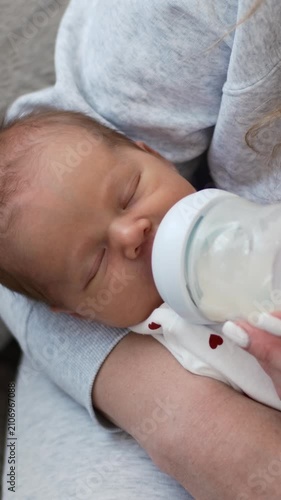 Sleepy Newborn Being Fed From A Bottle By Mom In Vertical Video