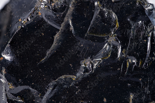 Black rock with shiny surface shows natural features in close up