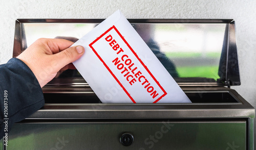 Photography Hand Placing a Debt Collection Notice Envelope into a Mailbox