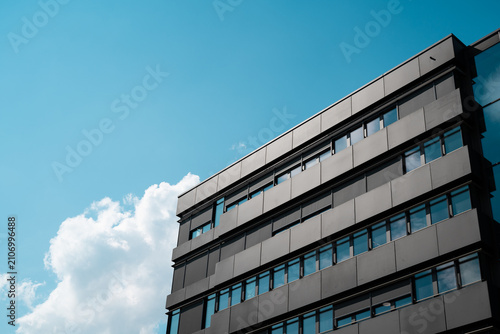 Modern office building with reflective windows and blue sky