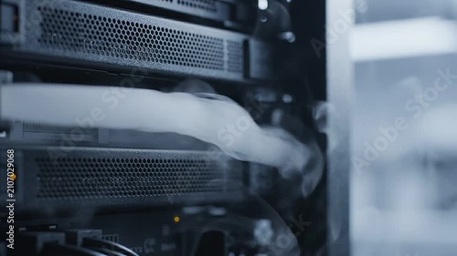 Smoke billowing from server rack in data center, showcasing the progression of heat dissipation and cooling mechanisms in a high-tech environment with visible hardware