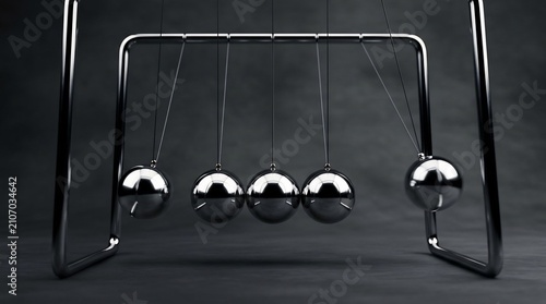 Chrome newton cradle pendulum demonstrating kinetic energy