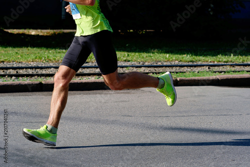 Foto Side profile cropped shot of a male runner in neon sportswear sprinting on an as