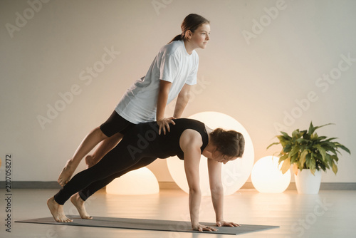 Foto Mom and teenage daughter do gymnastics together in the fitness room