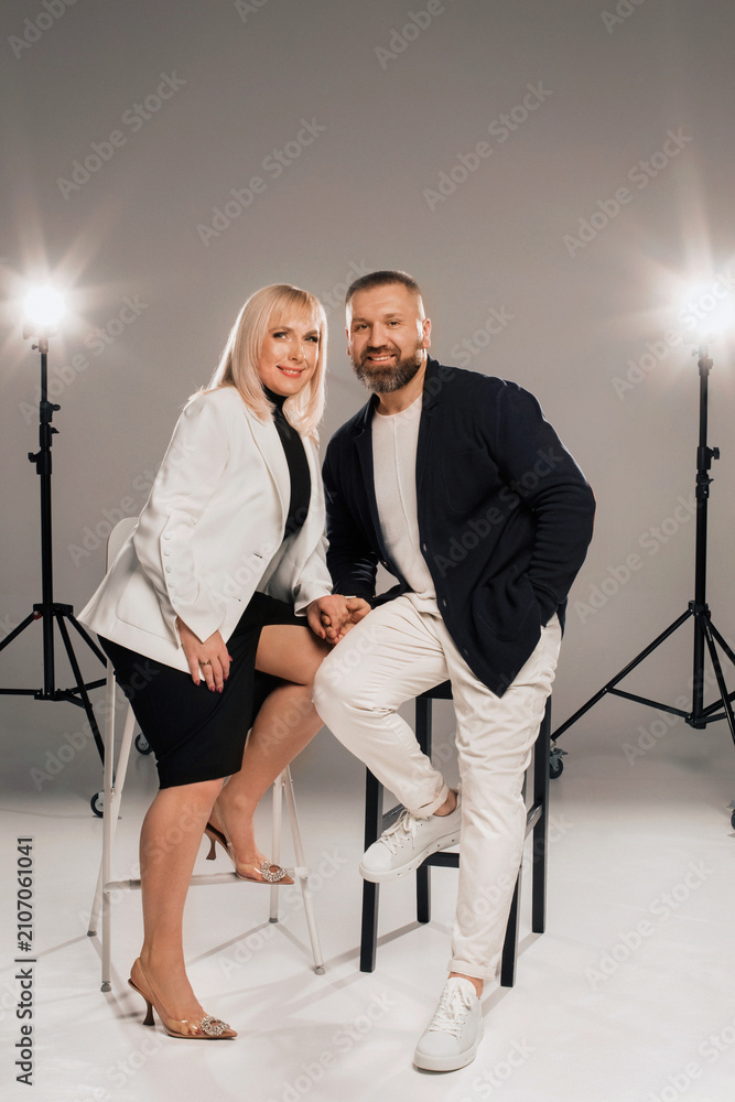 Obraz premium A man and a woman in strict clothes pose against the background in the studio