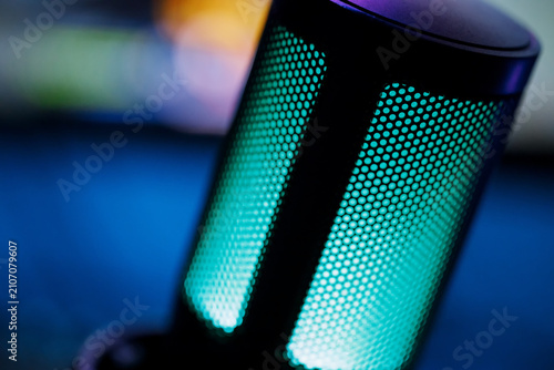 Dark cinematic macro of streamer mic on desk with RGB accent lighting
