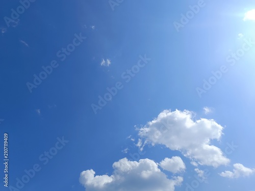 Canvas Print Bright blue sky with white cumulus clouds and sunlight