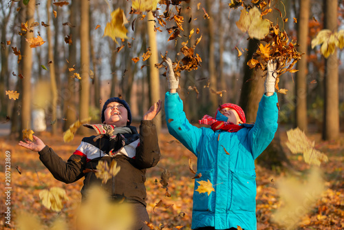 Children enjoy playing with leaves in a park during autumn in the afternoon