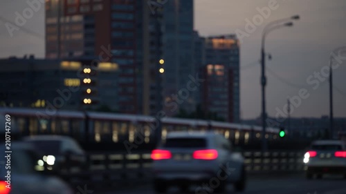 Blurred urban traffic with glowing car lights and city buildings at dusk, modern transportation and metropolitan lifestyle concept with motion atmosphere