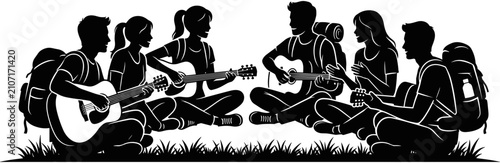 Valokuva Silhouette of diverse young friends sitting on grass with backpacks playing guitars, enjoying camping music and outdoor togetherness in nature