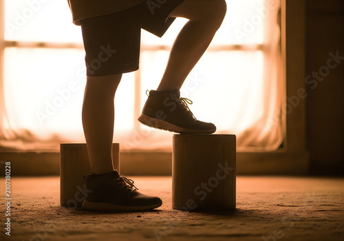 Person stepping on wooden blocks in a room with a window