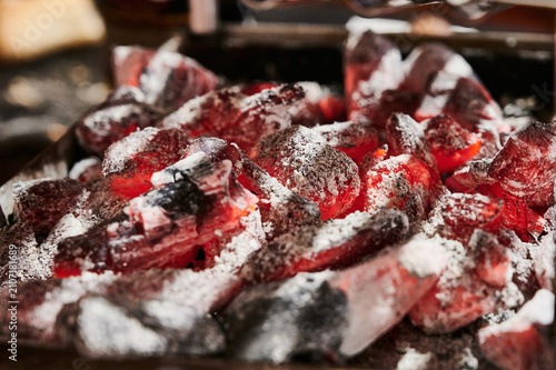 Glowing hot charcoal embers burning with white ash
