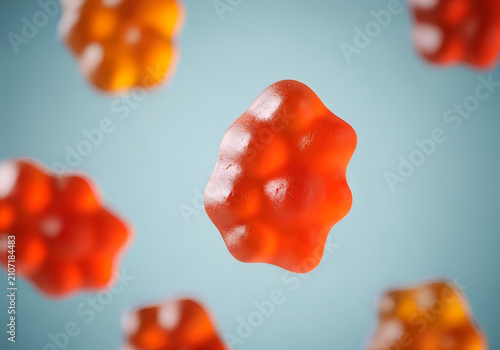 Floating gummy candies in studio lighting vibrant orange and red confectionery with shallow depth of field
