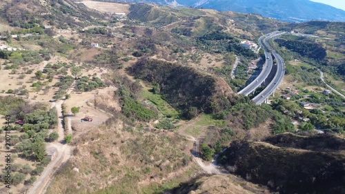 Aerial wide angle panoramic view of highway bridge entering tunnel