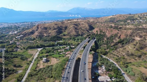 Aerial panoramic view of curved highway overpass toward sea bridge